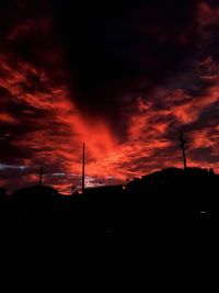 Silhouette built structure against orange sky