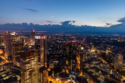 High angle view of city lit up against sky