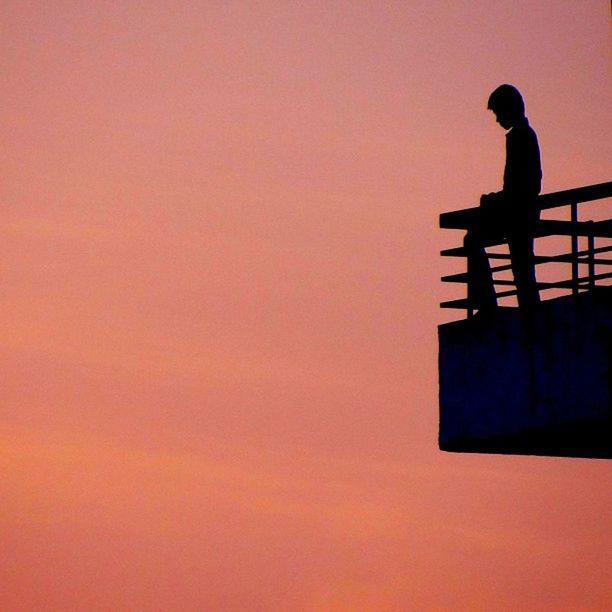 silhouette, sunset, orange color, men, copy space, lifestyles, standing, built structure, architecture, low angle view, leisure activity, building exterior, sky, clear sky, full length, side view, outline