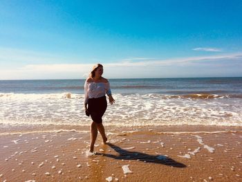 Full length of man standing on beach against sky