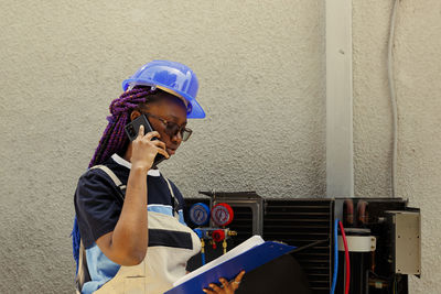 Side view of young woman using mobile phone at home