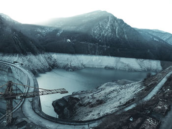 Scenic view of lake by snowcapped mountains against sky