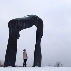 Woman standing at arch during winter