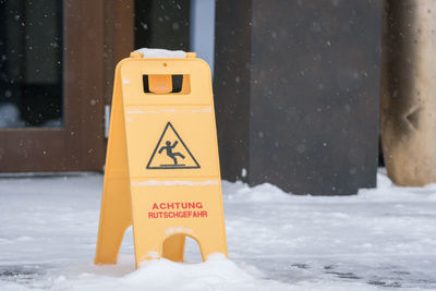 Yellow information sign on snow