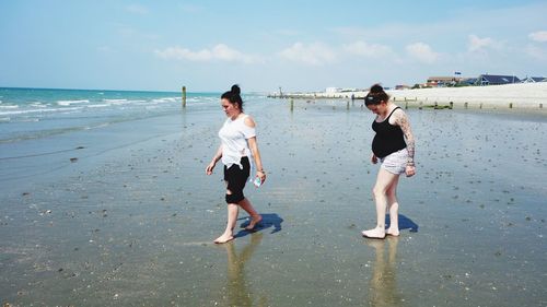 People on beach against sky