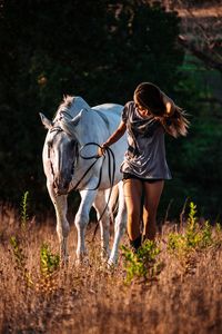 Woman riding horse on field