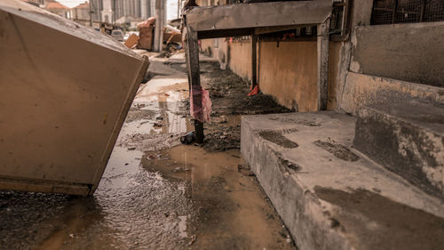 Wet road amidst buildings in city