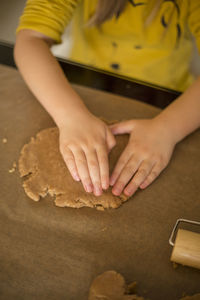 Midsection of girl preparing cookie at table