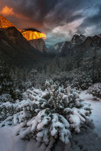 Scenic view of mountains against cloudy sky during sunset