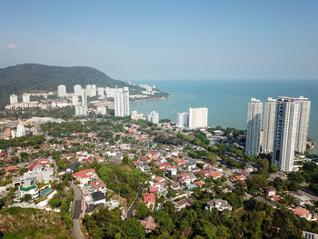 High angle view of buildings by sea against clear sky