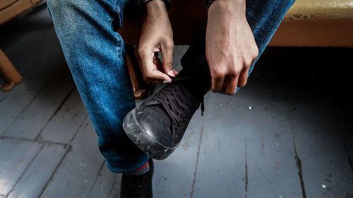Low section of man wearing shoe