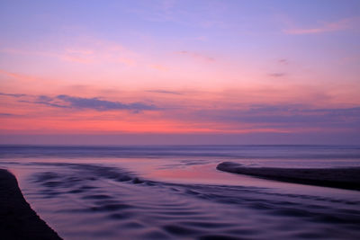 Scenic view of sea against romantic sky at sunset