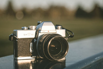 Close-up of old camera on retaining wall