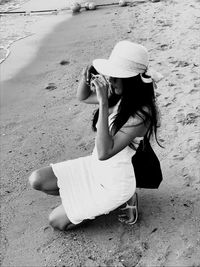 Woman sitting on sand at beach