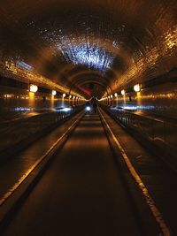 Empty road in illuminated tunnel