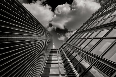 Low angle view of modern building against cloudy sky