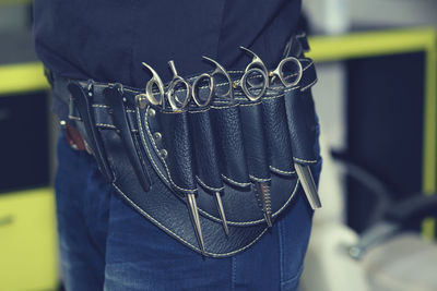 Midsection of hairdresser with scissors in hair salon