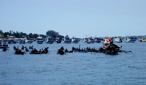 Panoramic view of people on sea against clear sky