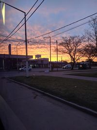 Road against sky during sunset in city