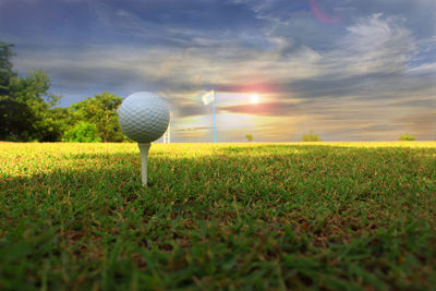 Ball on field against sky during sunset