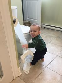 Full length of cute baby boy standing in toilet
