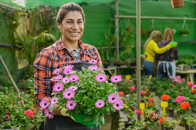 Cheerful hispanic gardener with flowers