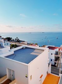 High angle view of swimming pool by building against sky