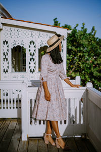 Rear view of woman standing against built structure