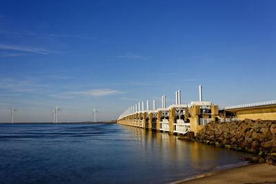 Bridge over river against blue sky