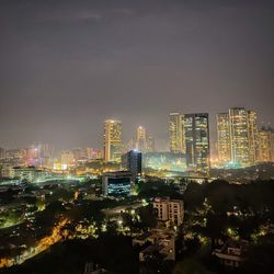 Illuminated buildings in city against sky at night