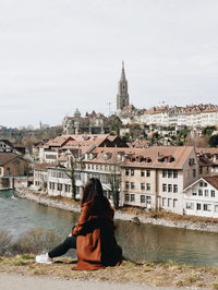 Woman looking at canal against buildings in city