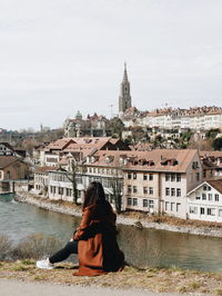 Woman looking at canal by buildings in city