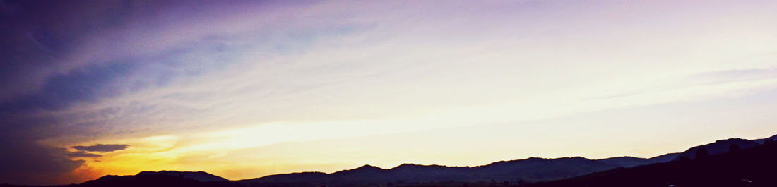 Scenic view of mountains against sky at sunset