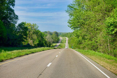 Road amidst trees against sky