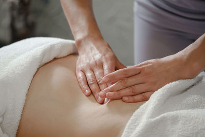 Top view of hands massaging female abdomen. therapist applying pressure on belly. woman receiving