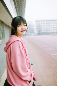 Portrait of a smiling young woman standing outdoors