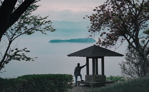 Man standing by tree against sky