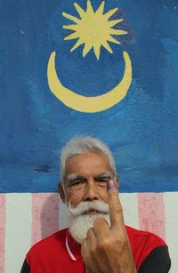 A man showing his finger after casting a voting during general elections