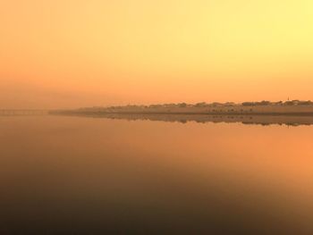 Scenic view of lake against orange sky