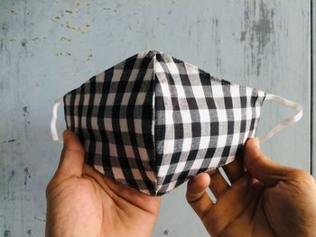 Midsection of person holding hands against wall