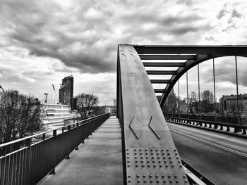 Bridge over river against cloudy sky