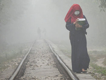 Woman standing on railroad track