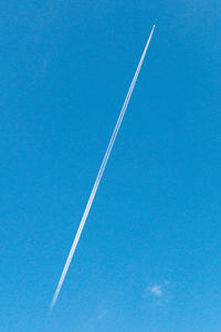 Low angle view of vapor trail in blue sky