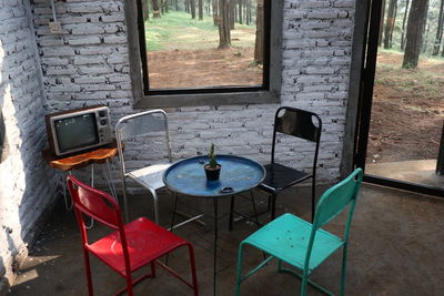 High angle view of empty chairs and table against window