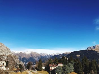 Houses and mountains against blue sky