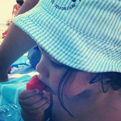 Close-up of little girl eating watermelon at beach