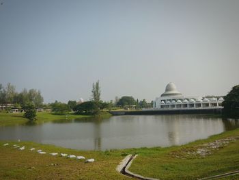 Built structure by river against clear sky