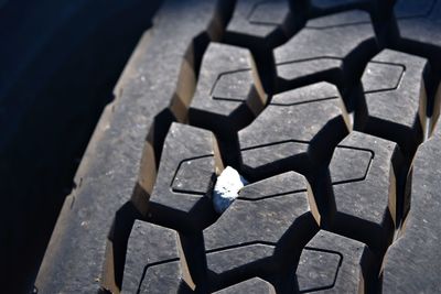 High angle view rock in a tire tread. insurance or transportation concept.