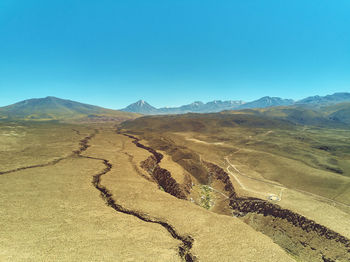 Scenic view of desert against clear blue sky