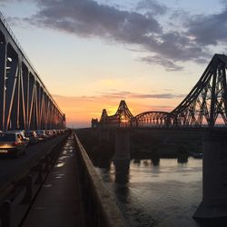 Bridge over river against cloudy sky